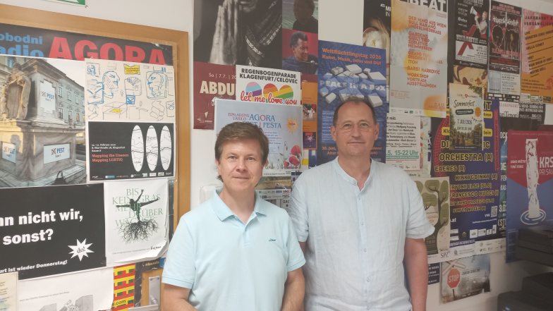 Auf dem Bild stehen zwei M&auml;nner nebeneinander in den R&auml;umlichkeiten von Radio AGORA.