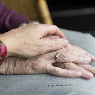 Alternativtext: Hände einer jungen und einer alten Person liegen übereinander
